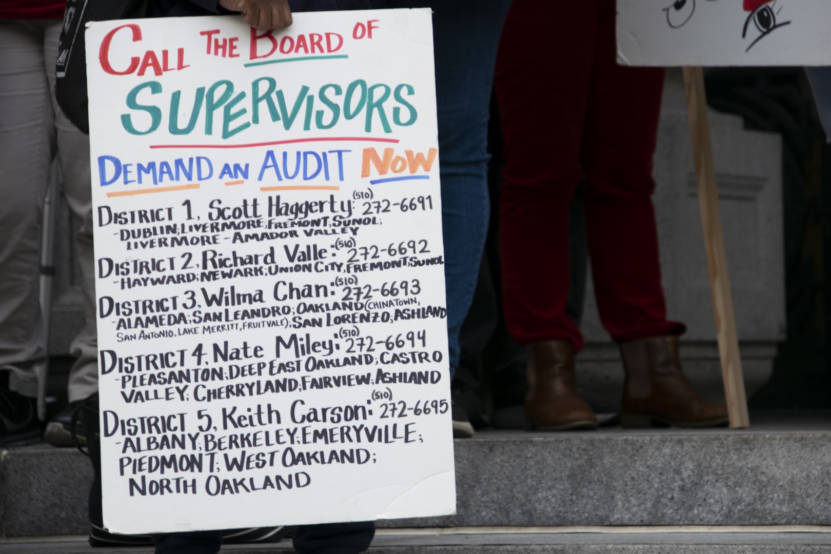 A protester carries a sign calling for an audit of the Alameda County Sheriff's Office outside Oakland City Hall on Tuesday. Photo: Scott Morris