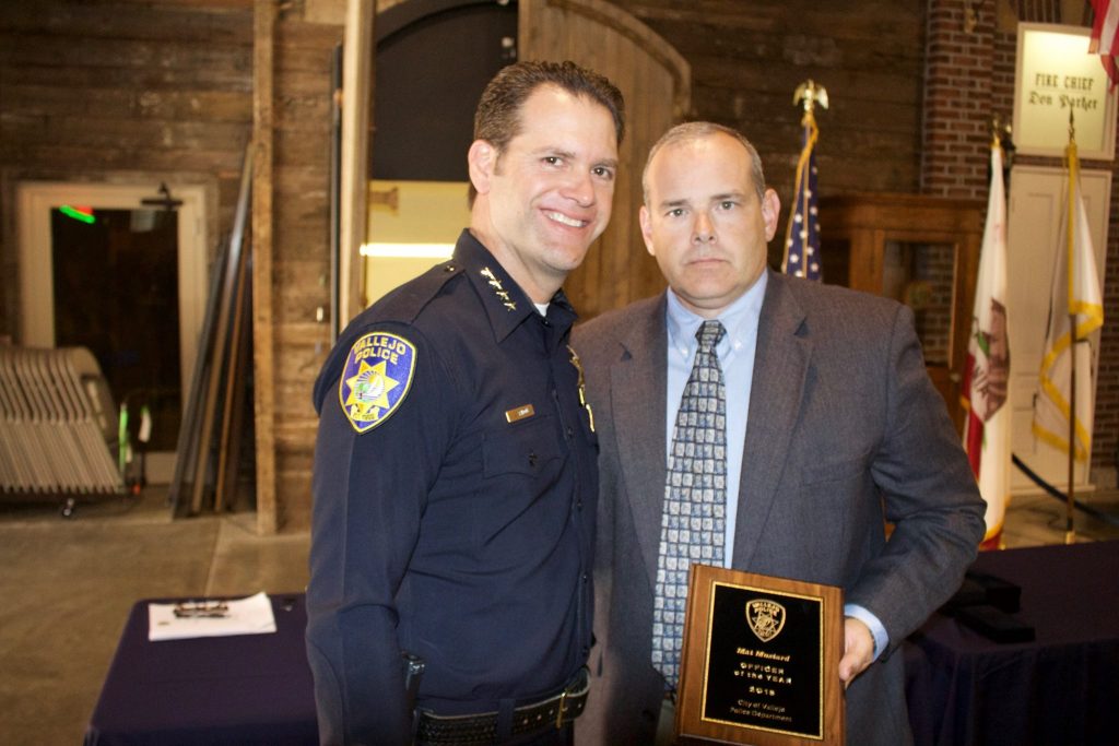 Vallejo police Chief Andrew Bidou, left, presents Detective Mat Mustard with the department's 