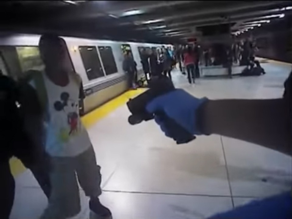 A BART police officer holds Michael Smith at gunpoint during an arrest at the Embarcadero station. Body camera still.